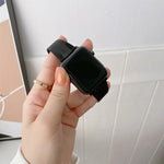 Buckle style steel replacement watchband for Apple Watch, showing a hand holding a black watch with a mesh strap.