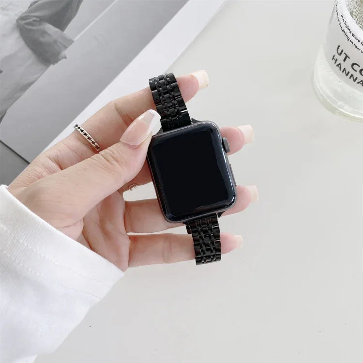 Steel replacement strap for Apple Watch, featuring a stylish black design, held in hand against a minimalist background.