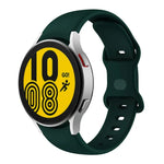 Butterfly buckle silicone watch band for Samsung Galaxy Watch4 on green strap, displaying digital time and activity.